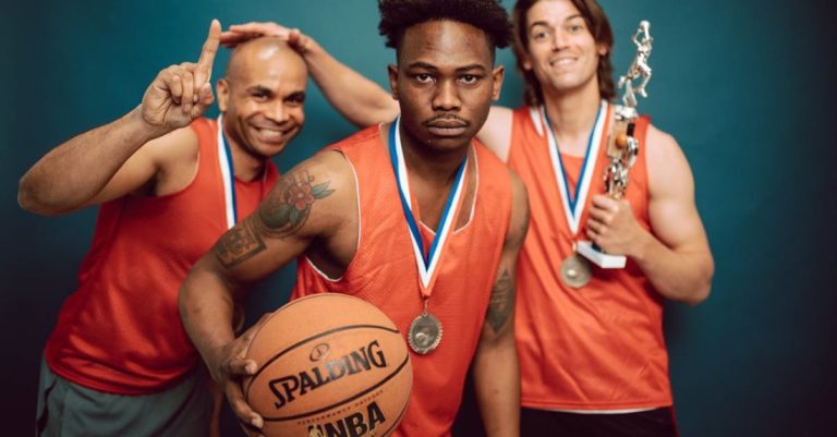 Sports Events - Three Men in Orange Jersey Shirt Holding Basketball