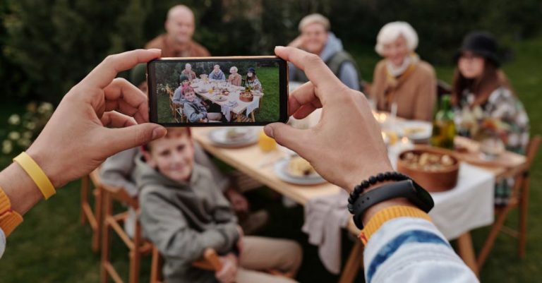 Reunion - Unrecognizable person taking photo of family dinner on smartphone