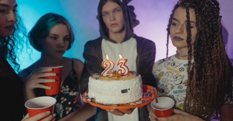 Birthday Party - Women Holding Disposable Cups Beside a Man Holding a Birthday Cake