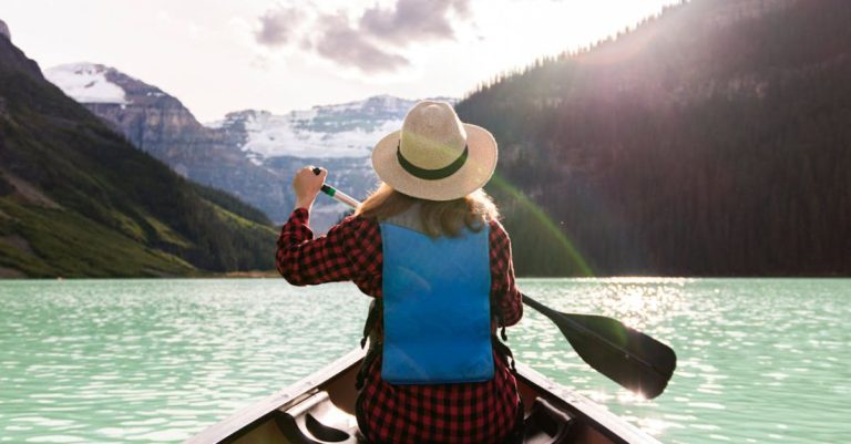 Canoeing - A Woman Paddling A Boat In The Lake