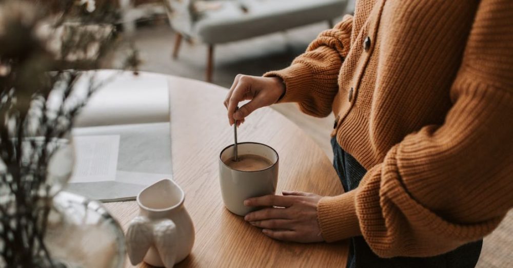 Winter Stay - A Person Mixing a Drink in a Mug